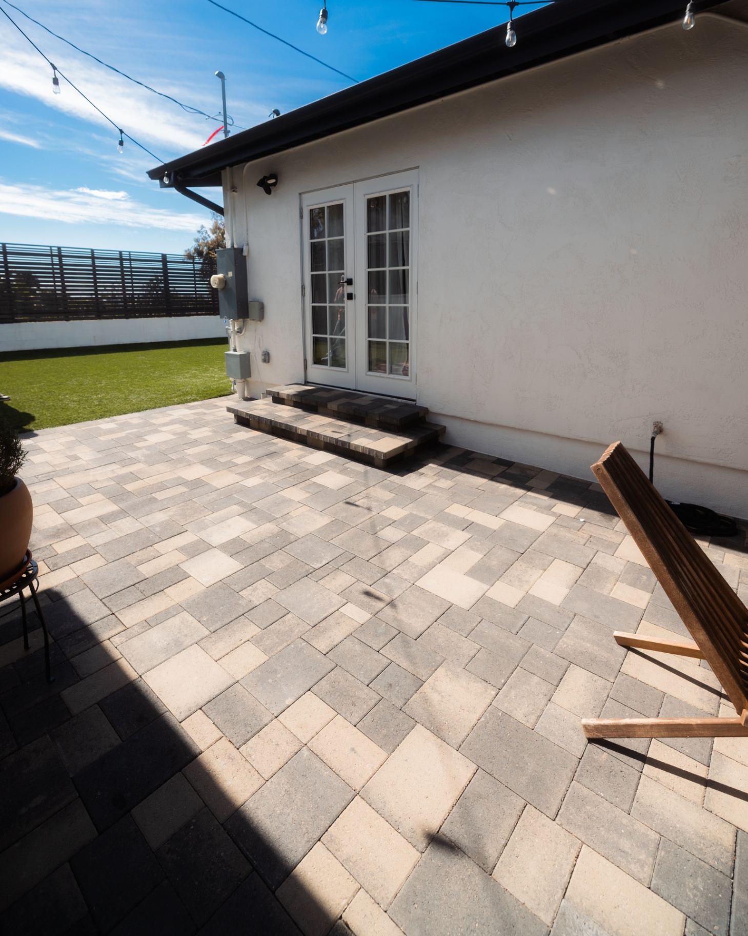 Gray paver patio outside white French doors