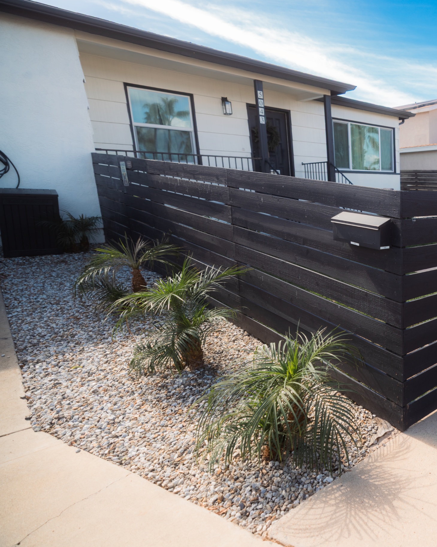 Horizontal wood front-yard fence with gravel planting bed