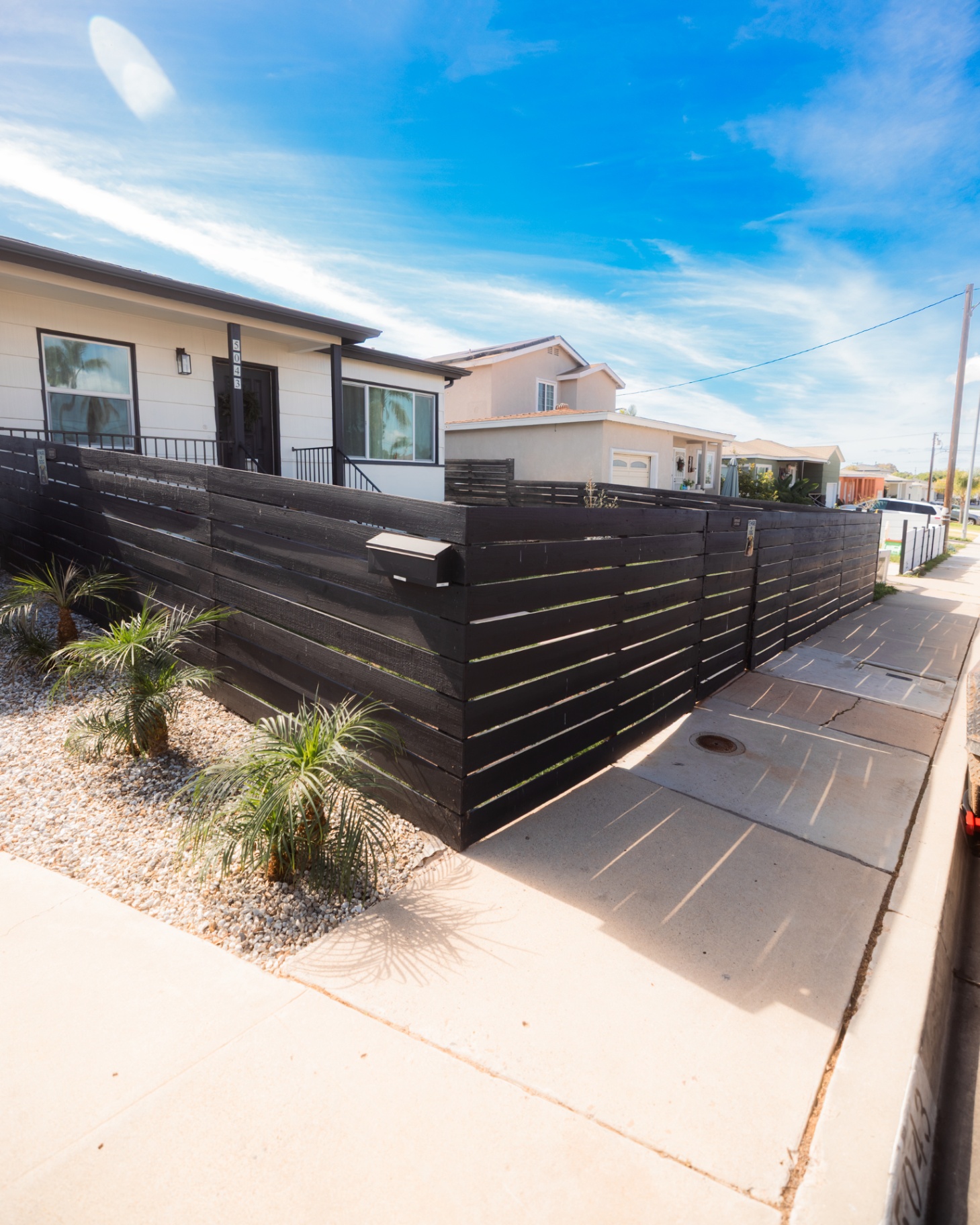 Horizontal wood front-yard fence beside a paved entry walk