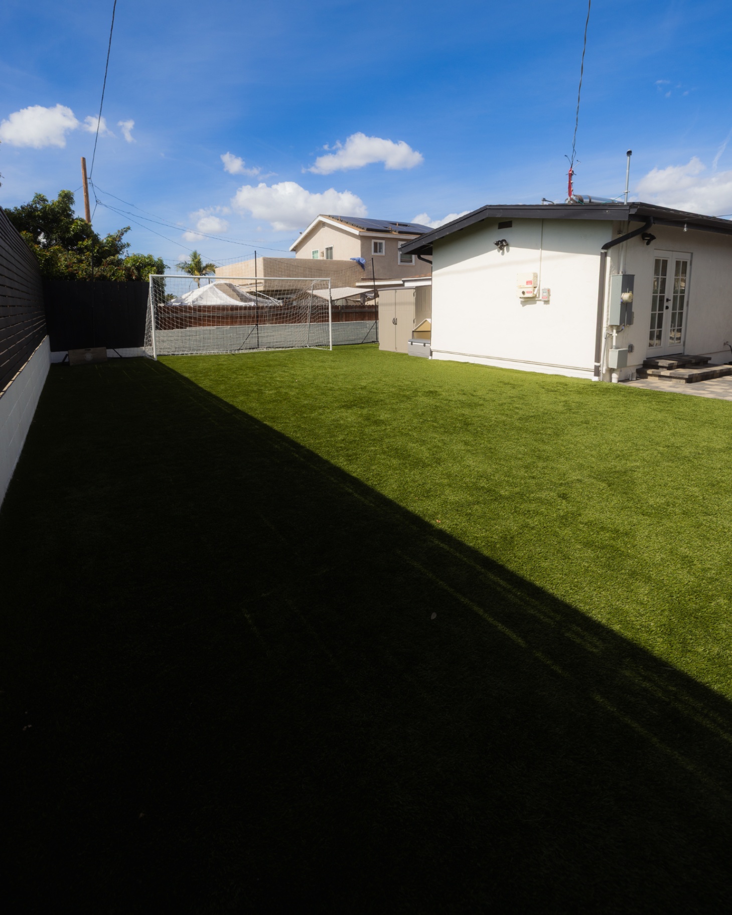 Artificial turf lawn beside a white vinyl fence