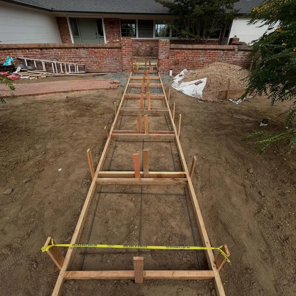 Wood formwork and rebar laid out for a long front walkway pour