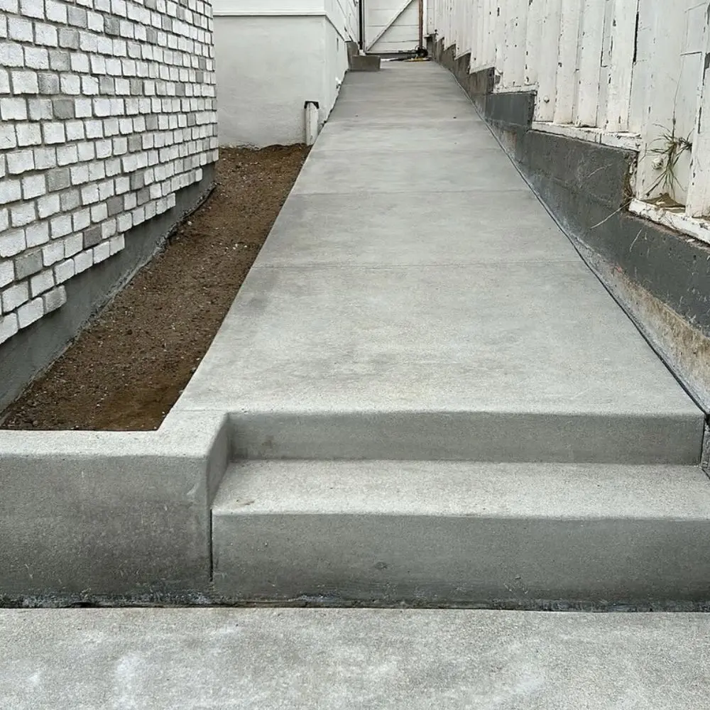 Poured concrete retaining wall along a narrow side yard walkway