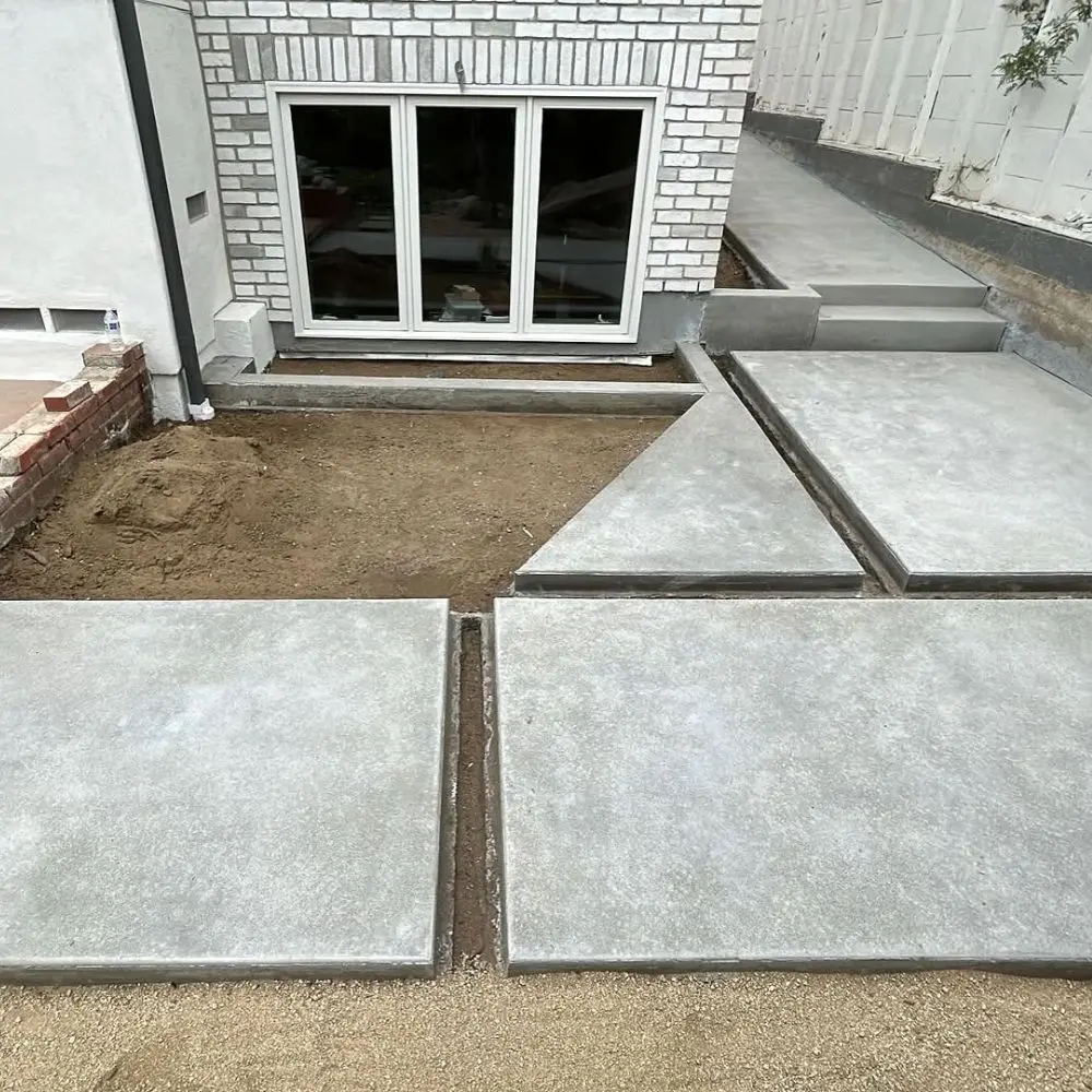Finished concrete slabs and wall along a narrow side yard