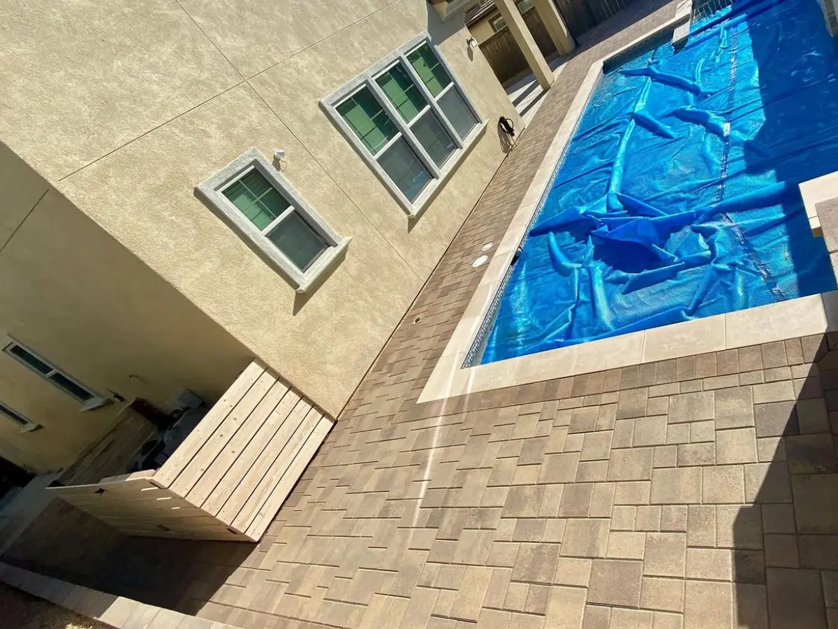 Large format paver pool surround with a cedar equipment enclosure